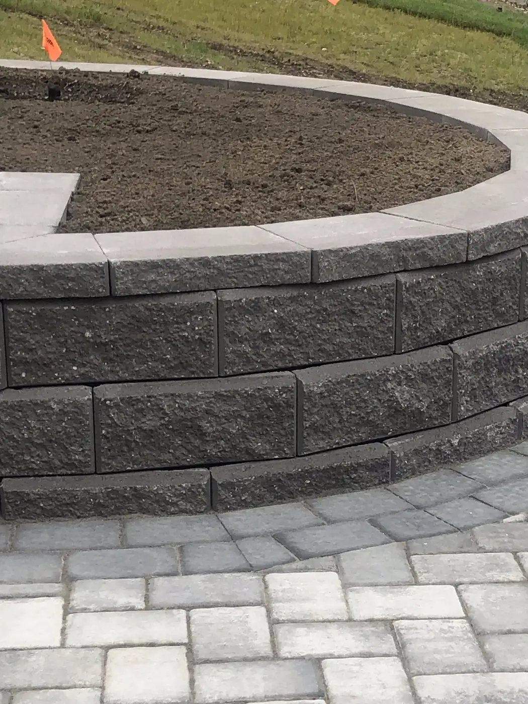 Segmental block retaining wall with a curved face
