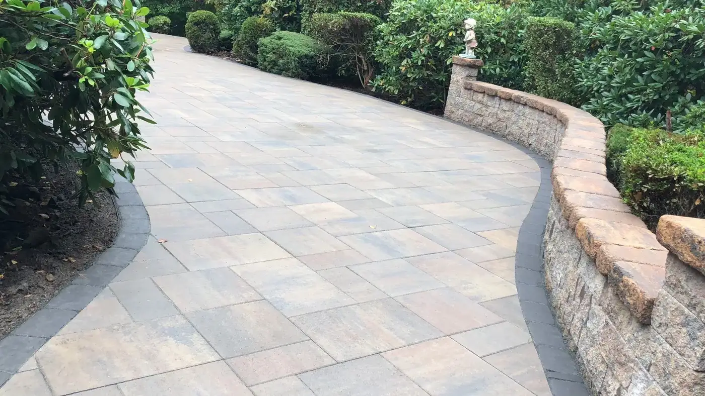 Curved paver walkway edged by a fieldstone wall